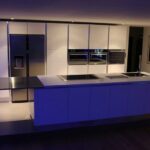 Cuisine sigma en laque brillante blanche, gorges en inox et plan de travail en corian