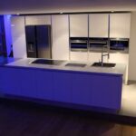 Cuisine sigma en laque brillante blanche, gorges en inox et plan de travail en corian